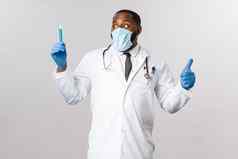 科维德冠状病毒病人治疗实验室概念非裔美国人医生医疗面具乳胶手套发明了治愈疫苗病毒流感显示翘拇指骄傲灰色背景