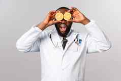 医疗保健健康的饮食疾病概念哇维生素肖像惊讶快乐非裔美国人医生self-distance吃维生素持有橙子眼睛