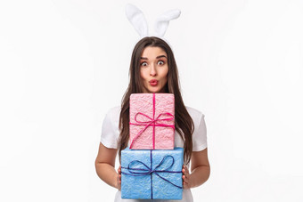 庆祝活动假期礼物概念肖像愚蠢的美丽的年轻的女兔子耳朵包礼物折叠嘴唇吻微笑给礼物白色背景