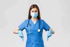 科维德防止病毒健康医疗保健工人检疫概念有关不高兴愤怒的女护士医生感觉可疑的指出手指穿医疗面具