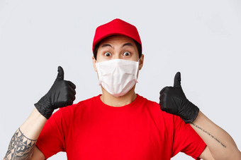 科维德self-quarantine在线购物交付概念热情的亚洲快递红色的帽t恤统一的穿医疗面具手套翘拇指推荐安全交付