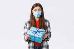 科维德生活方式假期庆祝活动概念兴奋可爱的生日女孩持有包装盒子好奇的内部收到礼物穿医疗面具防止冠状病毒爆发