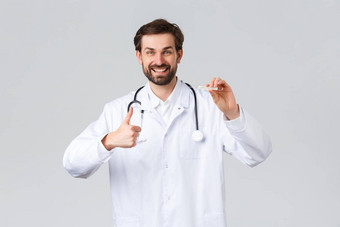 医院医疗保健工人科维德治疗概念英俊的友好的医生白色实习医生风云听诊器显示竖起大拇指测量病人温度完美的细显示温度计