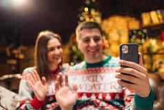 年轻的夫妇聪明的电话会说话的家庭祝贺快乐圣诞节视频调用会议应用程序现代技术容易安慰使用一年恭喜远程概念
