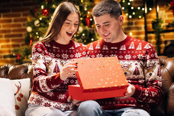 女人惊讶兴奋开放收到了礼物盒子快乐男人。使圣诞节礼物亲爱的女人概念假期浪漫惊喜假期奇迹