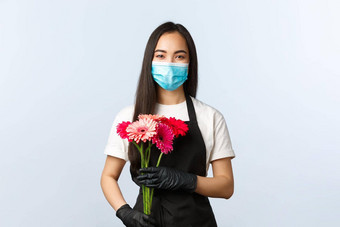 小业务冠状病毒流感大流行订单商店概念微笑可爱的亚洲女花店医疗面具持有花束客户销售花科维德爆发