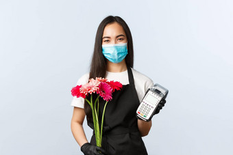 小业务冠状病毒流感大流行订单商店概念友好的微笑亚洲女员工商店穿医疗面具手套持有花束订单回来终端