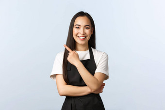 咖啡商店小业务启动概念快乐的亚洲女工作兼职咖啡馆穿黑色的围裙指出手指上左角落里邀请横幅广告