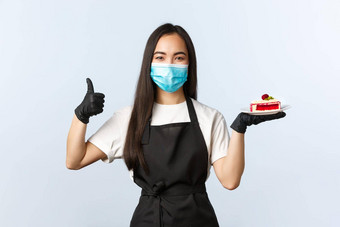 科维德社会距离小咖啡商店业务防止病毒概念好看的微笑加西安女咖啡师女服务员推荐美味的蛋糕菜单显示翘拇指