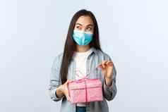 社会距离生活方式科维德流感大流行庆祝假期冠状病毒概念感兴趣快乐亚洲女人医疗面具打开礼物盒子思考内部