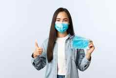 社会距离生活方式科维德流感大流行日常生活休闲概念可爱的友好的亚洲女孩显示医疗面具竖起大拇指推荐保护健康冠状病毒疾病