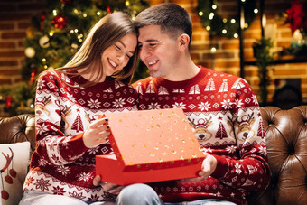快乐男人。使圣诞节礼物亲爱的女人肖像浪漫的夫妇开放现在礼物盒子晚上装饰圣诞节树概念假期浪漫惊喜