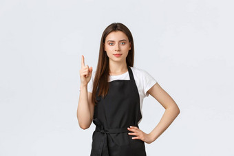 杂货店商店<strong>员工</strong>小业务咖啡商店概念年轻的可爱的女咖啡师黑色的围裙指出手指显示广告女售货员提供信息
