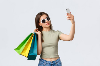 购物购物中心生活方式旅游时尚概念快乐有吸引力的女人旅游太阳镜摆姿势购物袋采取自拍购买的事情最喜欢的商店