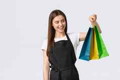 杂货店商店员工小业务咖啡商店概念可爱的微笑女售货员包装购买项目可爱的色彩斑斓的纸袋将订单工作收银员