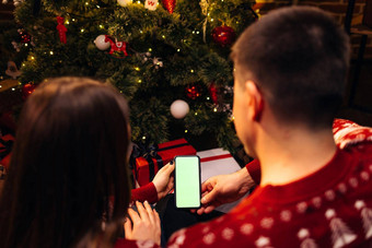 夫妇智能手机圣诞节视频调用绿色模拟屏幕圣诞节节日沟通技术手持有聪明的电话绿色模拟屏幕