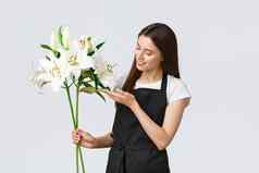 购物员工小业务概念可爱的温柔的花店花商店使完美的花束白色百合触碰叶微笑快乐处理在线订单交付花