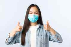 社会距离生活方式科维德流感大流行日常生活休闲概念支持热情的亚洲女人医疗面具竖起大拇指穿佩普杂货店购物