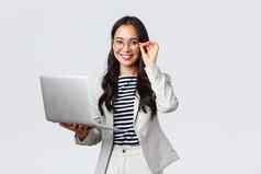 业务金融就业女成功的企业家概念自信微笑亚洲女商人办公室工人白色西装眼镜移动PC客户