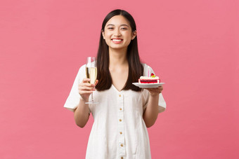 庆祝活动聚会，<strong>派</strong>对假期有趣的概念快乐亚洲女人庆祝生日享受美味的生日蛋糕喝香槟<strong>微</strong>笑相机快乐的粉红色的背景