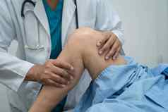 亚洲医生理疗师检查按摩治疗膝盖腿高级病人整形外科医师医疗诊所护士医院