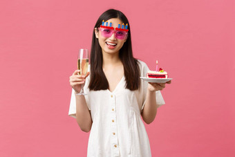 庆祝活动聚会，派对假期有趣的概念快乐的快乐亚洲女人庆祝生日有趣的太阳镜持有玻璃香槟生日蛋糕基斯蜡烛使