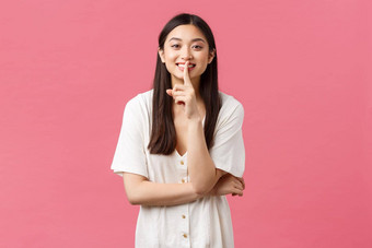 美人情绪夏天休闲概念迷人的愚蠢的亚洲女孩<strong>保持</strong>秘密嘘声可爱的微笑<strong>安静</strong>的礼貌地站粉红色的背景