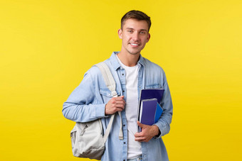 <strong>教育课程</strong>大学概念快乐的英俊的金发碧眼的的家伙微笑快乐携带背包笔记本电脑标题类站黄色的背景