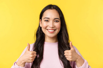 人情绪生活方式休闲美概念乐观的微笑亚洲女孩显示竖起大拇指批准站黄色的背景同意支持的想法黄色的背景