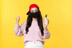 科维德社会距离生活方式防止病毒传播概念快乐的亚洲女孩脸面具冠状病毒推荐卫生产品显示手洗手液黄色的背景