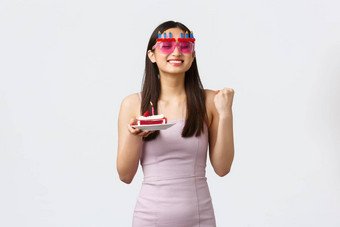 庆祝活动聚会，派对假期概念快乐的可爱的充满希望的亚洲女孩有趣的眼镜衣服加油鼓励积极的情绪持有一块蛋糕使生日
