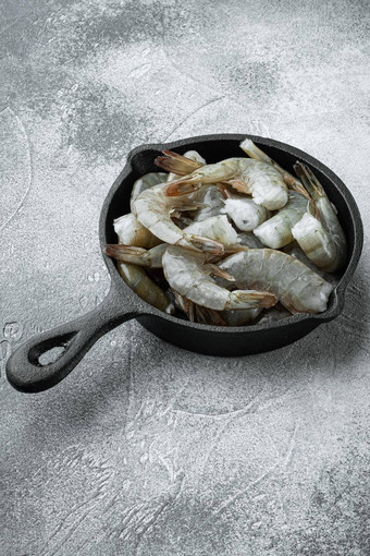 生新鲜的未煮过的虾虾投铁煎锅灰色的石头背景复制空间文本
