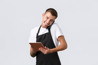 零售商店小业务咖啡馆餐厅外卖概念英俊的年轻的商店经理员工接收订单电话会说话的客户写作信息数字平板电脑