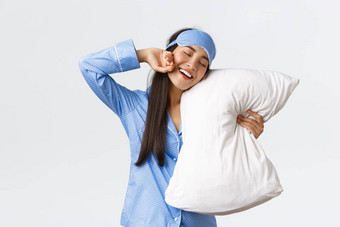 微笑很高兴可爱的亚洲女孩蓝色的睡衣睡觉面具拥<strong>抱枕</strong>头伸展运动手很高兴最后床上睡眠醒着的早....白色背景