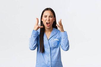 疯了愤怒的亚洲女孩蓝色的睡衣争论论点女朋友在外过夜说<strong>脏话</strong>诅咒摇晃手愤怒的站白色背景