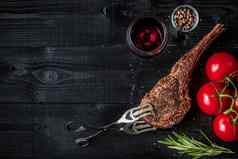 烧烤干岁的肋骨牛肉香料蔬菜玻璃红色的酒特写镜头黑色的木背景