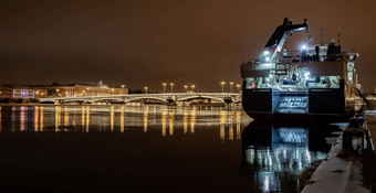 全景镜头冬天晚上城市圣彼得堡风景如画的反射水大船停泊布拉戈维申斯基桥中尉施密特以撒大教堂背景