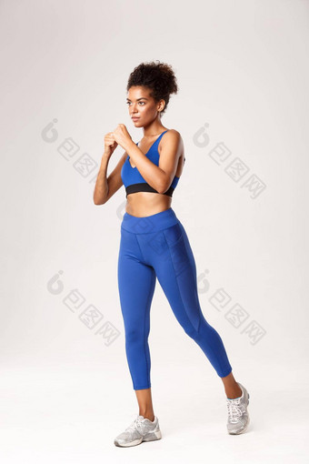 完整的长度非洲美国女运动员蓝色的运动服装实践盒子拳太极拳锻炼白色背景