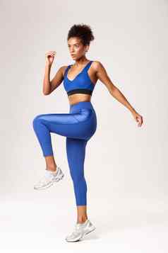 完整的长度确定健身女孩蓝色的运动服装锻炼健身房站白色背景