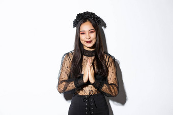 图像快乐感激的年轻的亚洲女人哥特花边衣服扣手微笑感激站白色背景