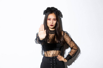 图像亚洲女人万圣节服装女巫显示停止手势禁止禁止不高兴自信脸站白色背景
