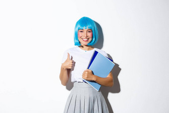 图像美丽的微笑亚洲女孩胭脂脸颊穿蓝色的动漫假发持有学校笔记本电脑穿着女<strong>学生</strong>万圣节聚会，派对显示竖起<strong>大拇指</strong>批准