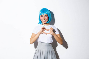肖像可爱的亚洲女孩卡哇伊显示心手势微笑站白色背景万圣节服装蓝色的假发