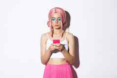 图像时尚的魅力女孩粉红色的假发移动电话站聚会，派对装白色背景