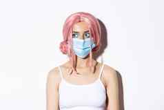 特写镜头年轻的女人粉红色的假发医疗面具社会距离科维德流感大流行庆祝万圣节安全措施