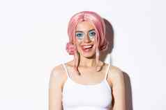 特写镜头快乐美丽的女模型粉红色的假发显示舌头微笑庆祝假期仙女服装站白色背景