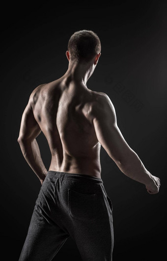 惊人的肌肉发达的男人。健身模型躯干显示肌肉回来