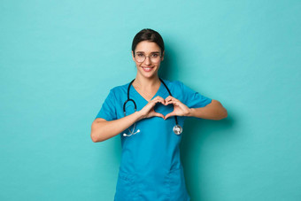 冠状病毒流感大流行社会距离概念图像微笑美丽的医生实习医生风云显示心标志采取护理病人站蓝色的背景