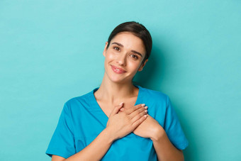 冠状病毒社会距离健康概念特写镜头微笑有吸引力的女医生感觉感激的持有手心感激之情站蓝色的背景