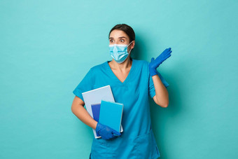 科维德流感大流行医学概念图像惊讶女实习生医疗面具手套实习医生风云持有笔记本电脑左惊讶站蓝色的背景